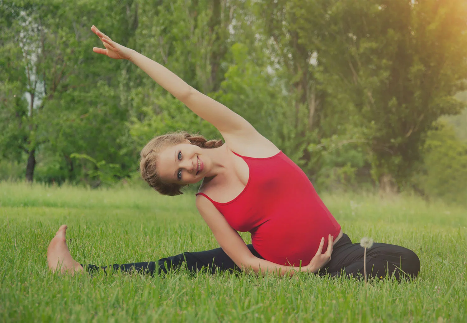 Jovem grávida e saudável fazendo yoga na natureza